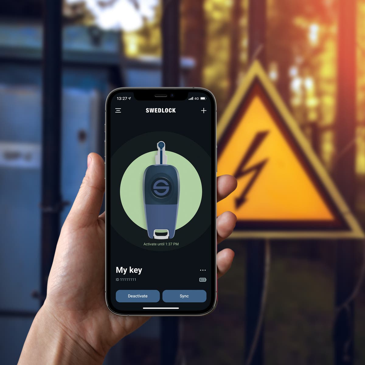 En hand som håller en mobiltelefon där en Swedlock nyckel får behörighet